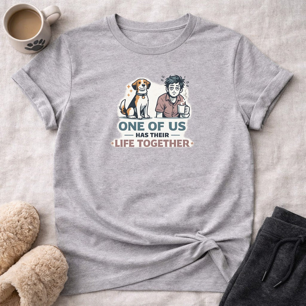Gray t-shirt with illustration of man and dog, text reads "ONE OF US HAS THEIR LIFE TOGETHER".