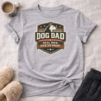 Gray t-shirt with "Dog Dad Real Men Pick Up Poop" text and paw print emblem.